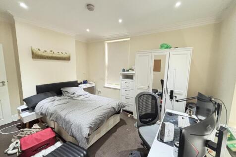 A well-lit, tidy bedroom featuring a double bed...