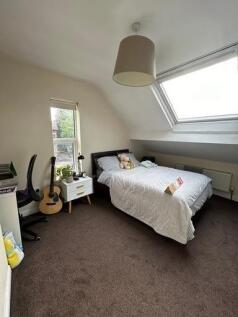 A bright and cozy bedroom with a large window p...