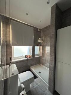 A modern, clean bathroom featuring a large show...