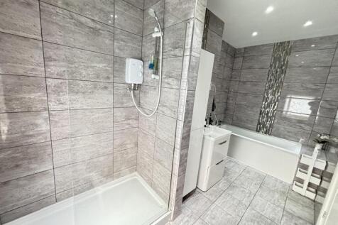 A modern and clean bathroom featuring a bathtub...