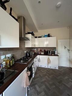 A modern kitchen featuring white cabinetry, a t...