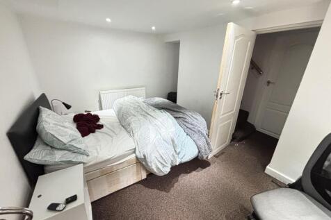 A spacious, well-lit master bedroom featuring a...