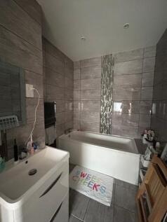 A modern bathroom featuring a bathtub with a ve...