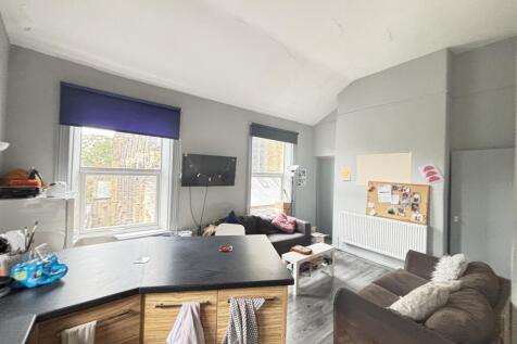 A well-lit and modern living room featuring lar...