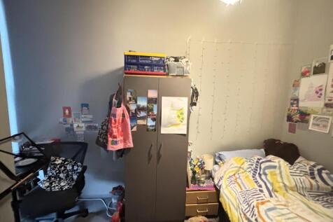 A cozy bedroom featuring a bed, wardrobe, and p...