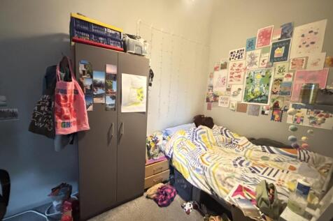 A cozy bedroom with a single bed, decorated wit...