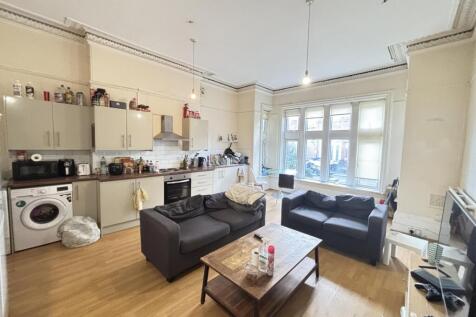 Bright and spacious living room featuring large...