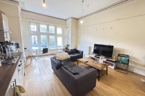 A bright and welcoming living room featuring la...