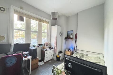 The bedroom features a comfortable bed, a desk ...