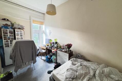 A modest bedroom featuring a bed, some personal...