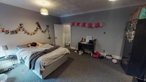 A spacious master bedroom featuring a large bed...