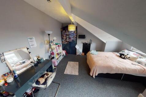 A neatly kept bedroom with a single bed and a s...