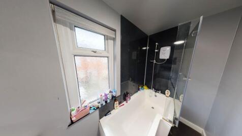 Bright and clean bathroom featuring a white bat...