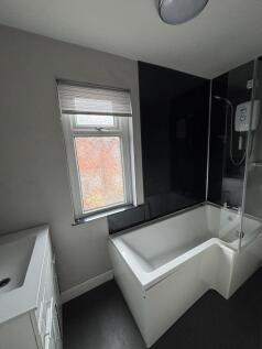 A modern, bright bathroom featuring a large bat...