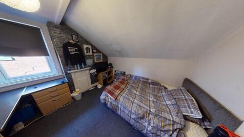 A cozy single bedroom featuring a neatly made b...