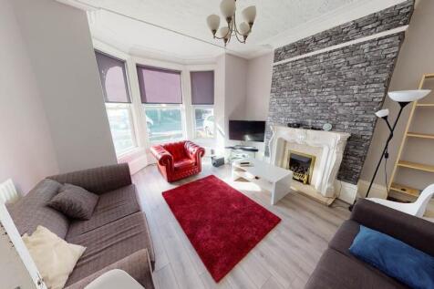 A spacious, well-lit living room featuring cont...