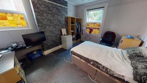 A cozy bedroom featuring a bed and a window tha...