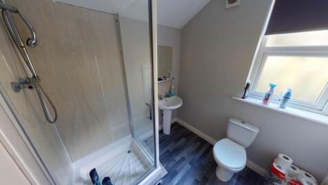 A clean and bright bathroom featuring a shower,...