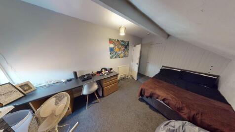 A cozy bedroom featuring a double bed and a wor...