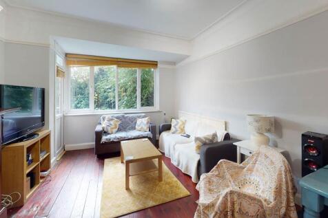 A spacious, well-lit living room with large win...