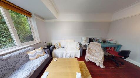 A spacious, well-lit living room featuring comf...