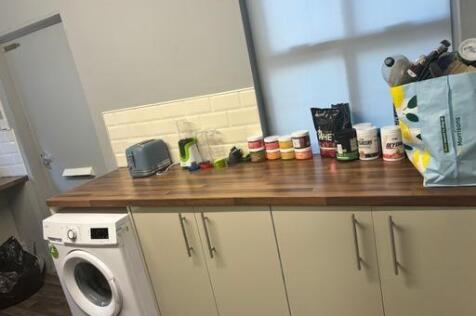 A compact kitchen area featuring a wooden count...