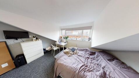 A spacious and well-lit bedroom featuring a lar...