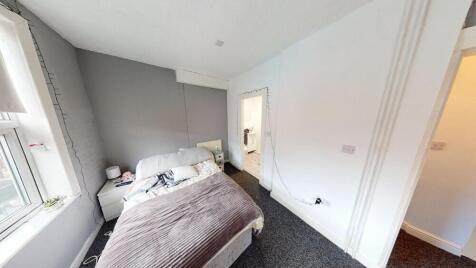 A well-lit, tidy double bedroom featuring a com...