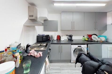 Modern and well-lit kitchen area with ample wor...