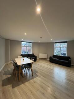 A bright and spacious living room with large wi...