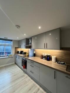 A modern, well-lit kitchen with sleek grey cabi...