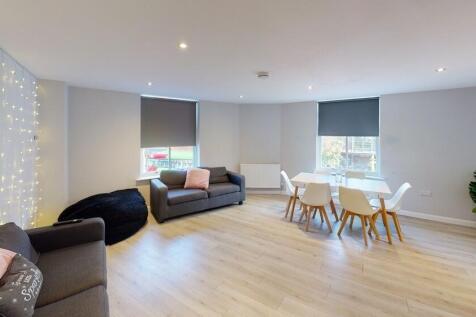 A spacious, modern living room filled with natu...
