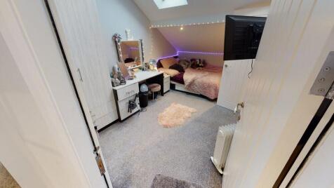 A cozy bedroom featuring a large bed, a study d...