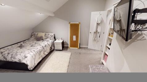 A bright and cozy bedroom featuring a large dou...