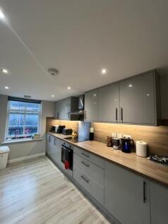 Modern and well-lit kitchen with ample counter ...