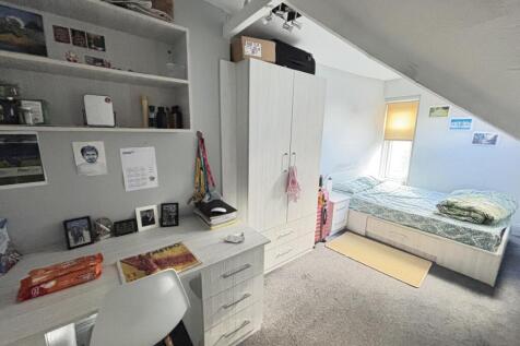 Bright and cozy single bedroom with a neatly ma...