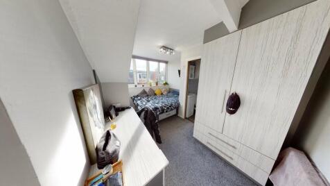 A spacious and well-lit master bedroom featurin...