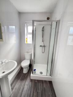 A bright and clean small bathroom featuring a s...