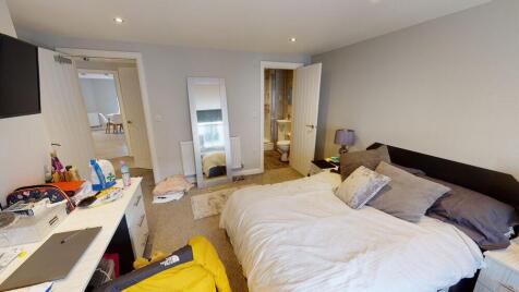 A spacious double bedroom featuring a comfortab...