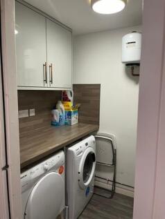 A tidy utility room featuring washing machines ...