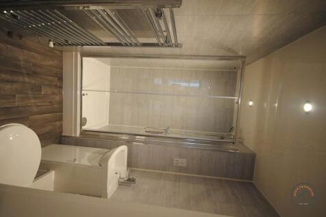 A well-lit, modern bathroom featuring a toilet ...