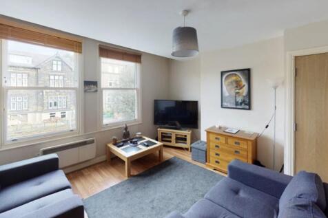 A well-lit, spacious living room featuring comf...