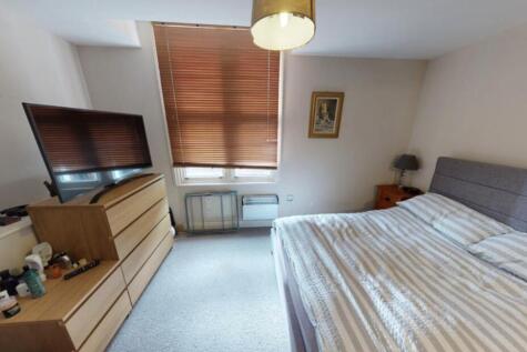 A well-lit and tidy bedroom featuring a double ...