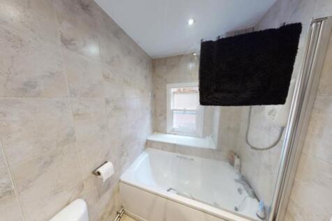 A well-maintained bathroom featuring a bathtub ...