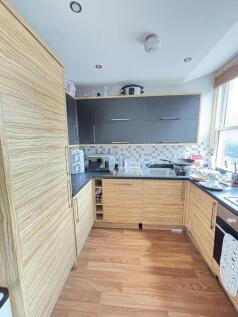 A modern, well-lit kitchen with ample cabinet s...
