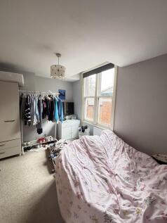 A cozy bedroom featuring a double bed and a win...