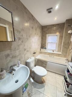 A modern bathroom featuring a bathtub, toilet, ...