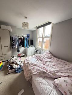 A small, lived-in bedroom featuring a double be...