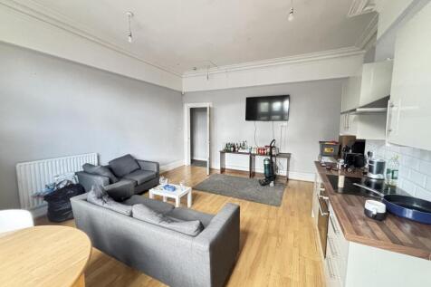 A spacious and modern living room featuring com...