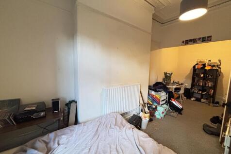 A cozy bedroom featuring a cozy bed with a head...